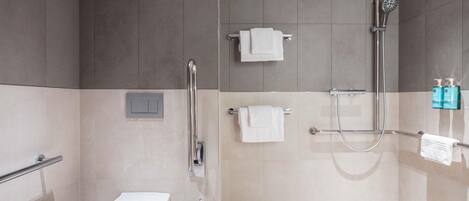 A modern bathroom with a shower, toilet, and towel rack.