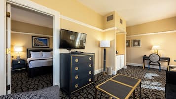 Una habitación de hotel con cama, tocador, televisión, escritorio y una silla.