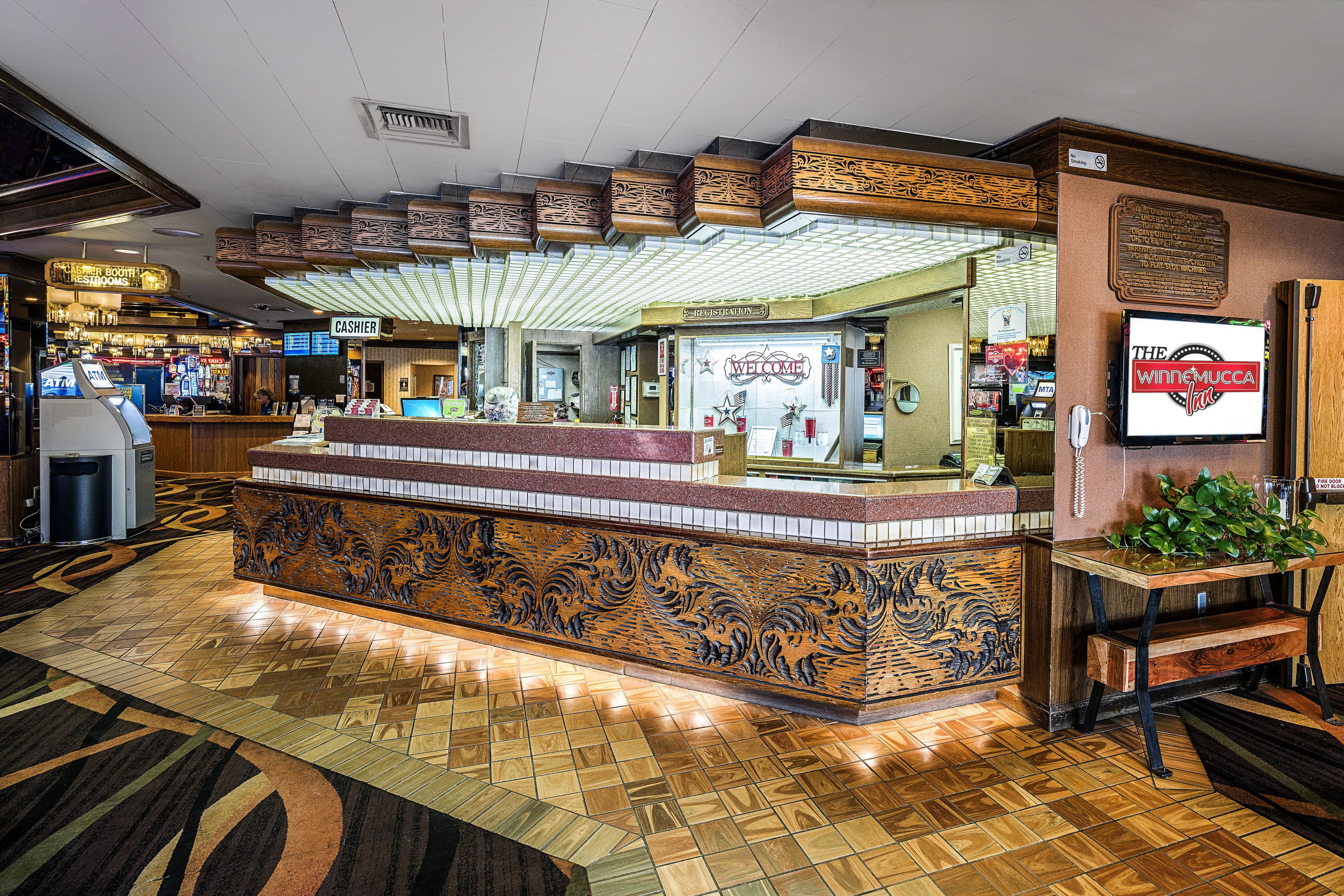 A reception area with a counter, a cash register, and a sign that reads "CASHIER".