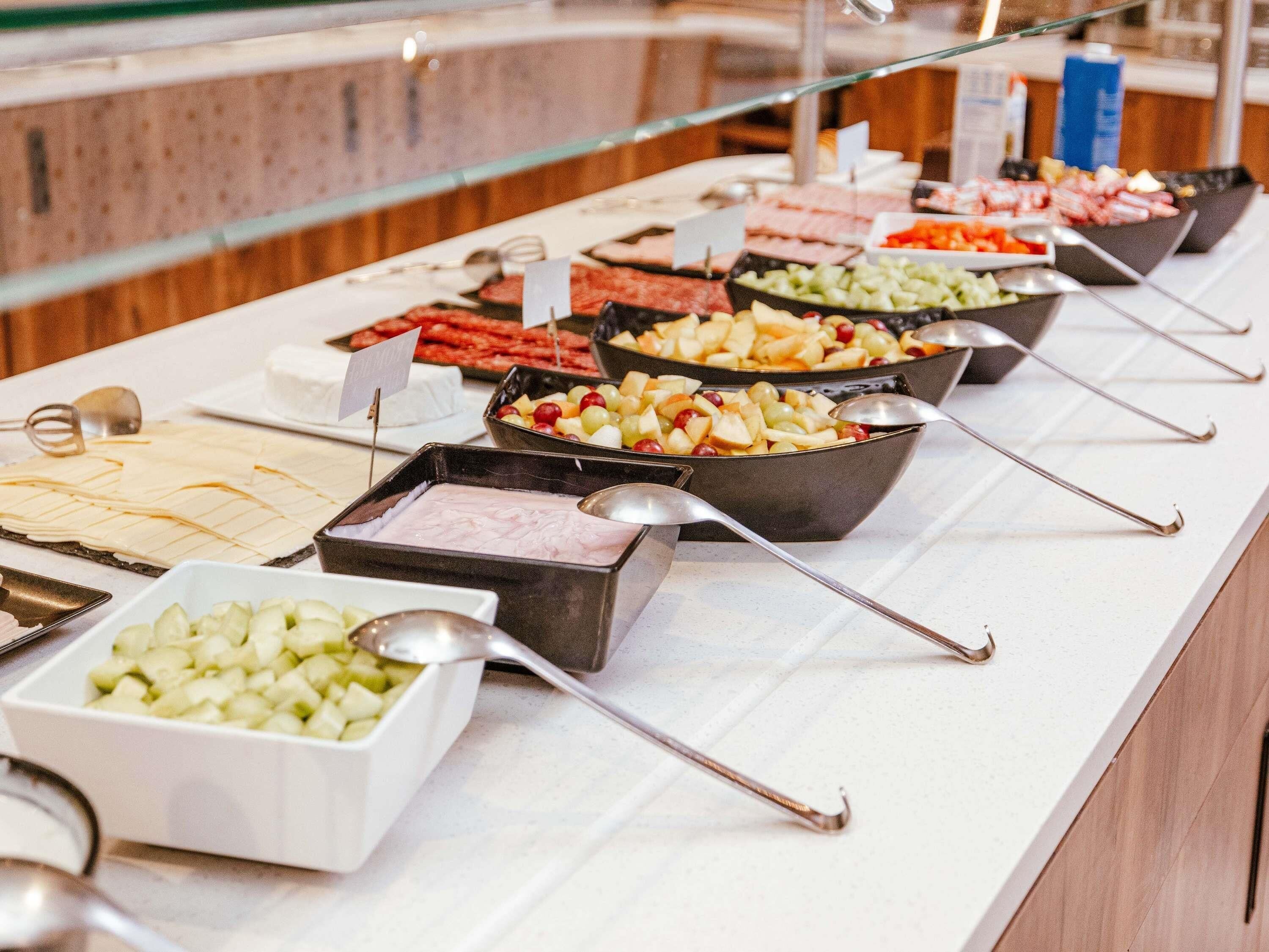A buffet with various food options and serving utensils.