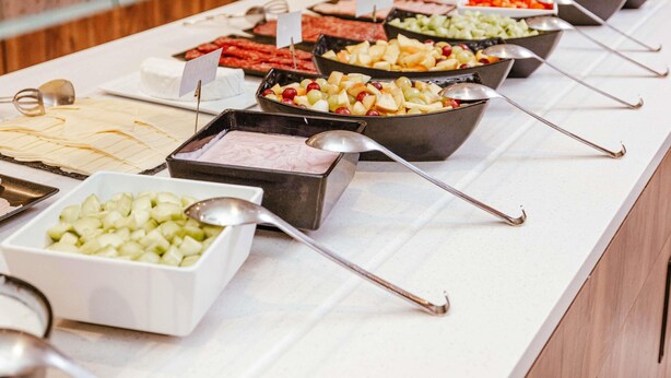 A buffet with various food options and serving utensils. - ibis Luxembourg Aéroport (Niederanven)
