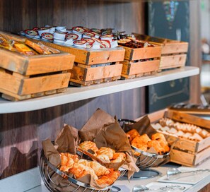 A buffet with various food items displayed in wooden crates and baskets. - ibis Luxembourg Aéroport (Niederanven)