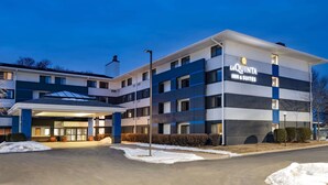 A multi-story hotel with a modern design, featuring a prominent entrance with a covered area and a sign that reads "La Quinta Inn & Suites."