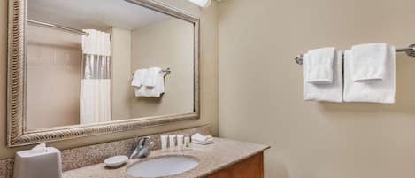 Une salle de bain équipée d’un lavabo, d’un miroir, d’un porte-serviettes et de toilettes.