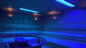 A sauna with wooden benches and blue lighting.