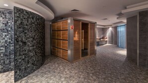 A modern hotel lobby with a curved wall, a wooden cabinet, and a patterned floor.