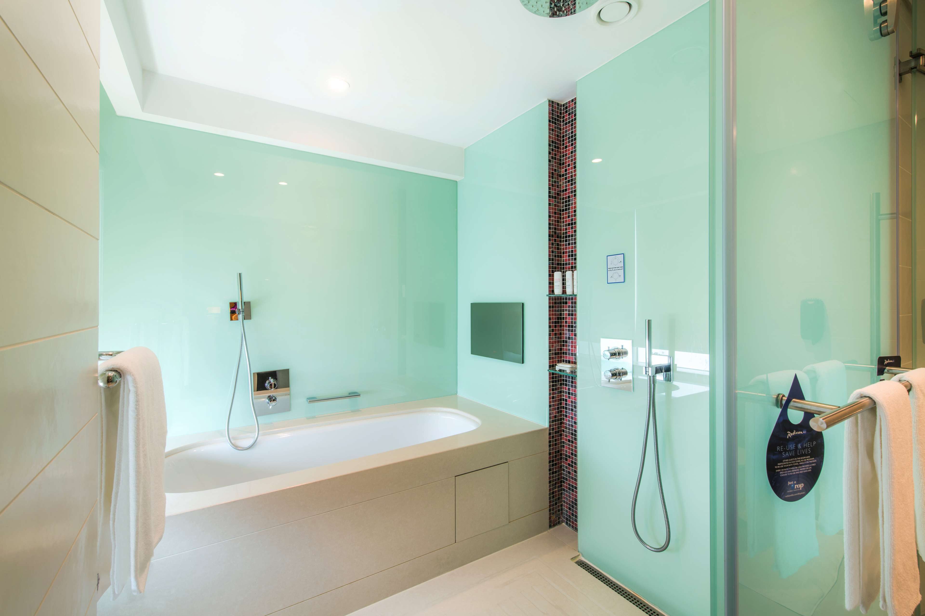 Ein modernes Badezimmer mit Badewanne, einer Glasdusche und einem Handtuchhalter.