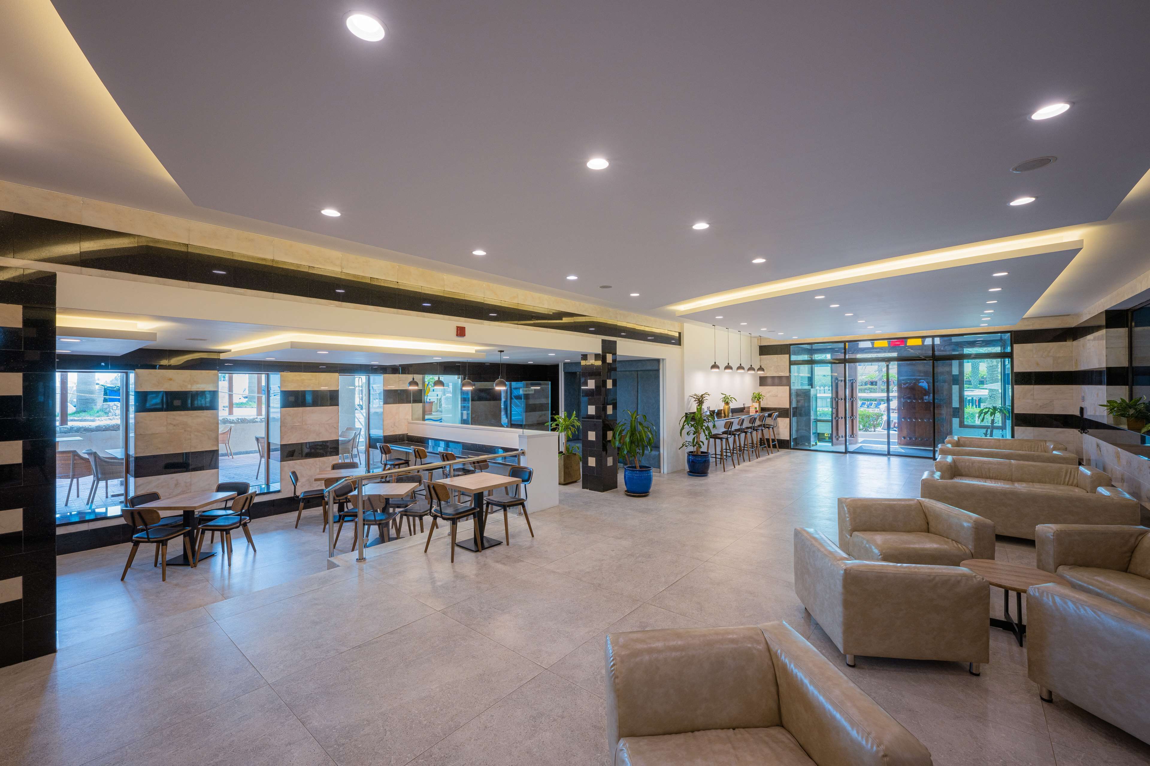 Un hall amplio con asientos modernos, una zona de bar y ventanas grandes con vistas.