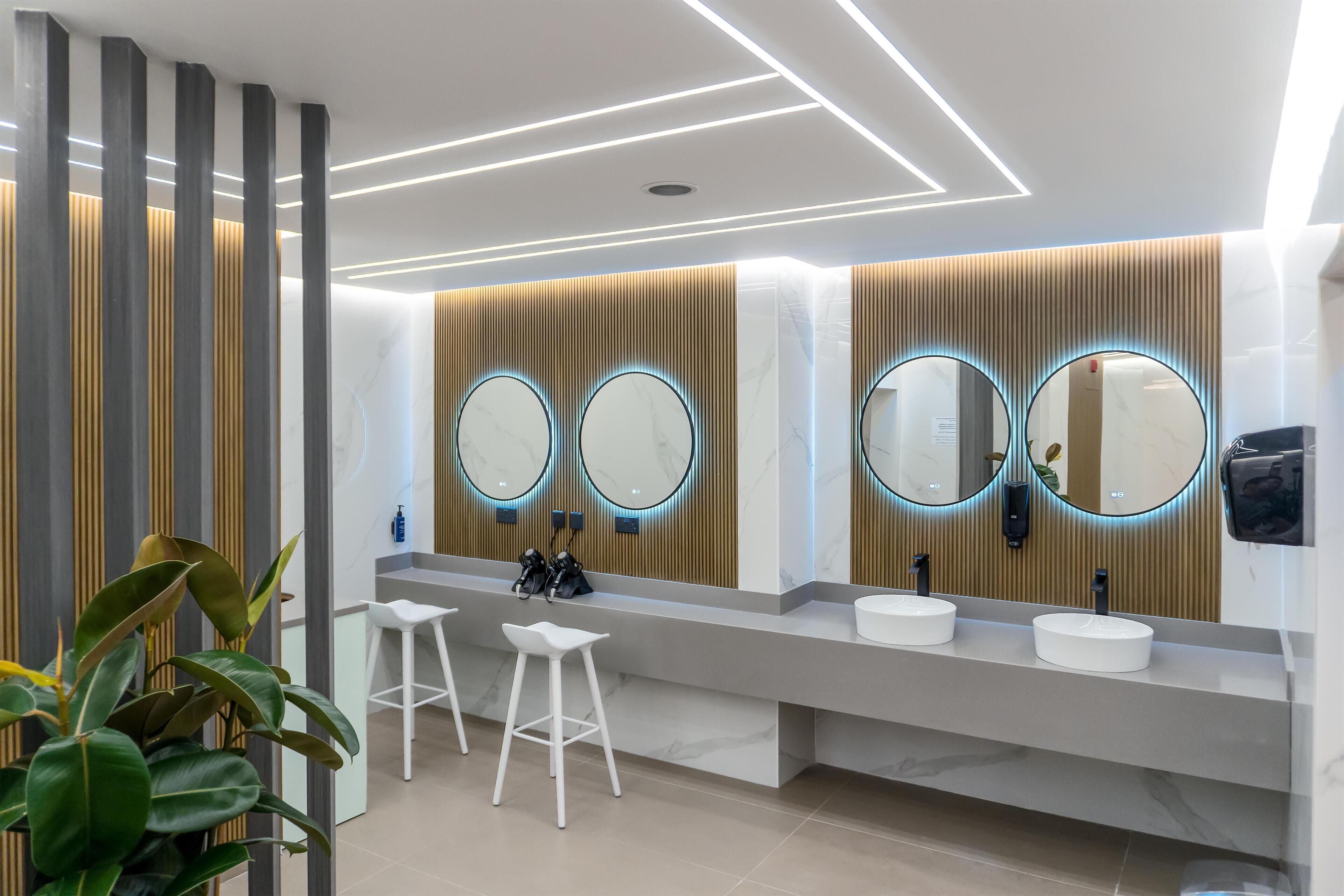 Ein modernes Badezimmer mit zwei Waschbecken, Spiegeln und einem Handtuchhalter.