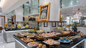 A buffet area with various food items and a chalkboard sign that reads "Salads".