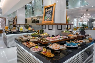 Un área de bufé con diferentes opciones de comida y un pizarrón con la inscripción 'Salads'.