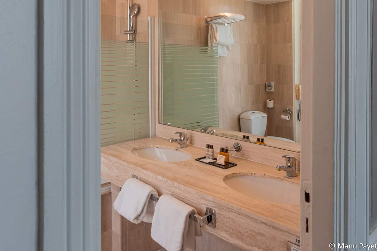 double deluxe room - side street view | bathroom | designer toiletries, hair dryer, towels