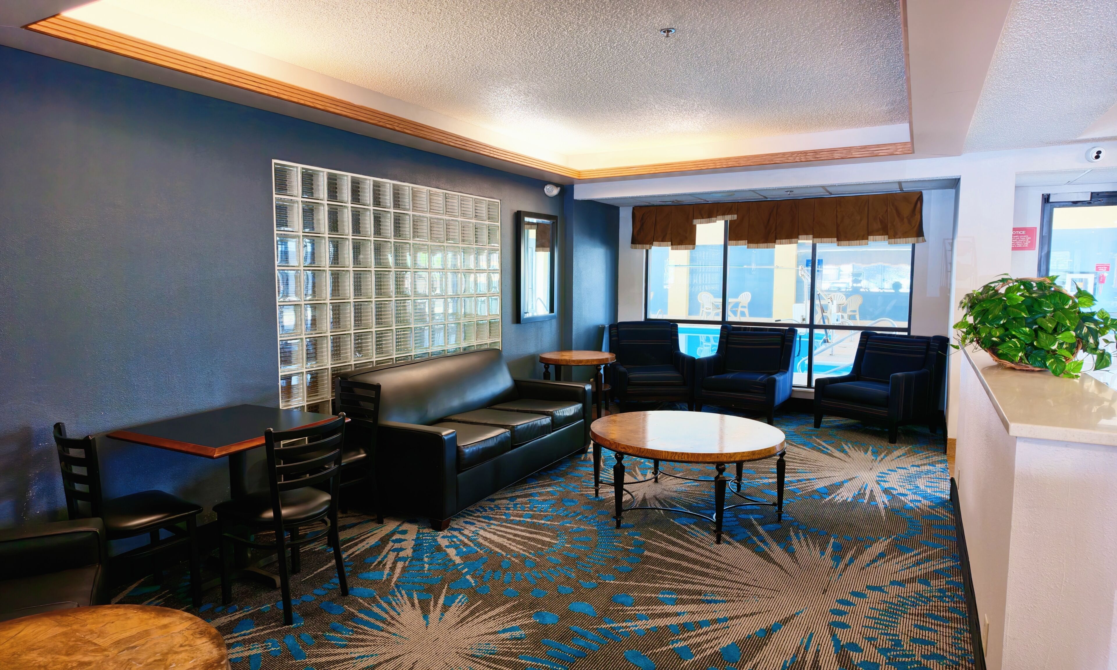 A lounge area with a sofa, chairs, a small table, and a patterned carpet.