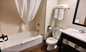 A bathroom with a bathtub, toilet, sink, and a towel rack.