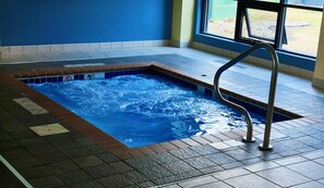 A hot tub with a metal ladder, surrounded by tiled flooring, and a window with a view of the outdoors. - Days Inn by Wyndham Fargo/West Acres (Fargo)