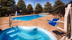 A swimming pool with a hot tub, surrounded by a fence and trees. - Best Western Torchlite (Wheatland)