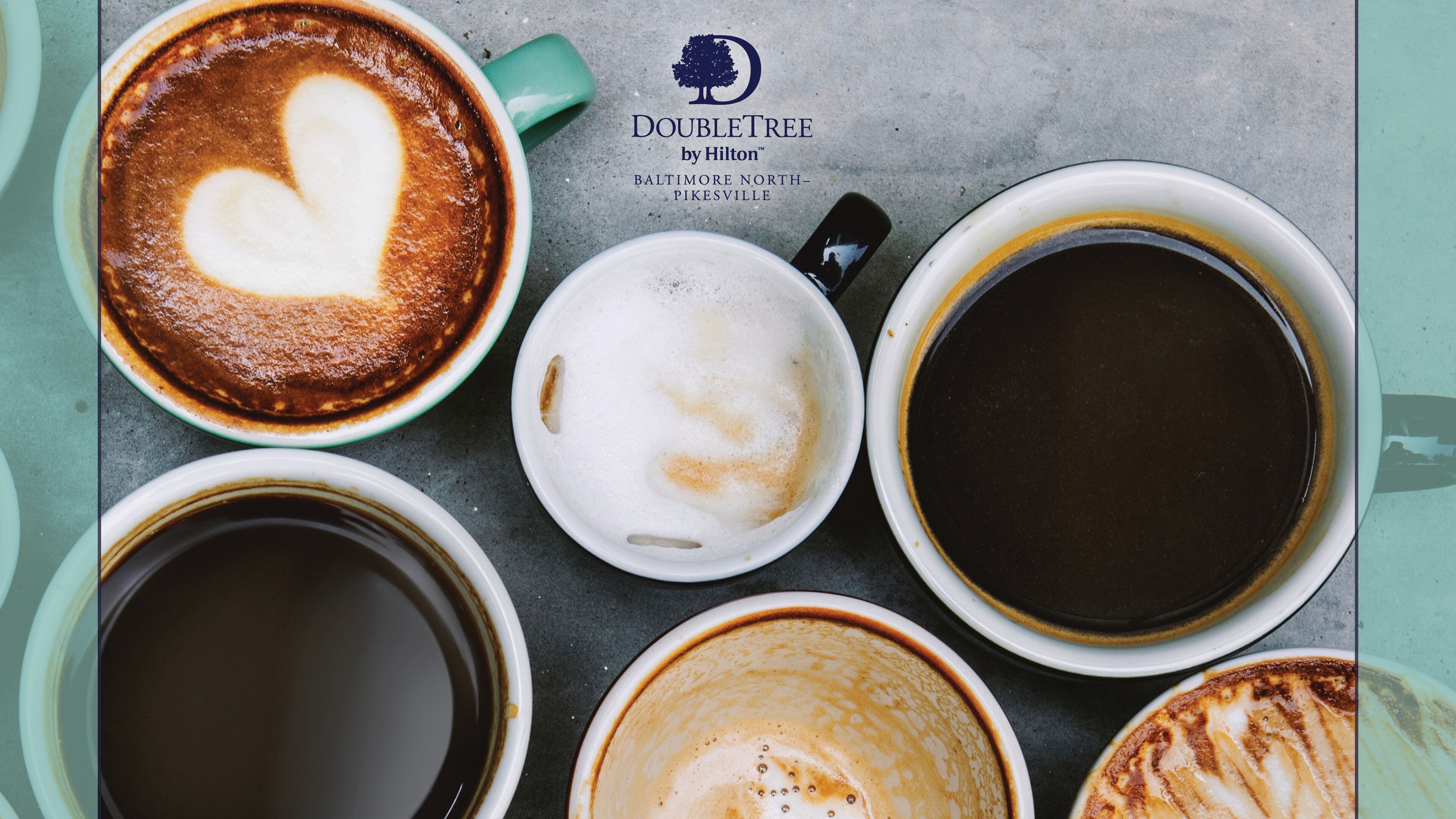 A variety of coffee cups with different designs, including latte art, on a table.