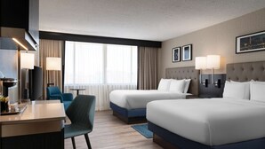 A hotel room with two beds, a desk, a chair, and a TV. - DoubleTree by Hilton Baltimore North - Pikesville (Pikesville)