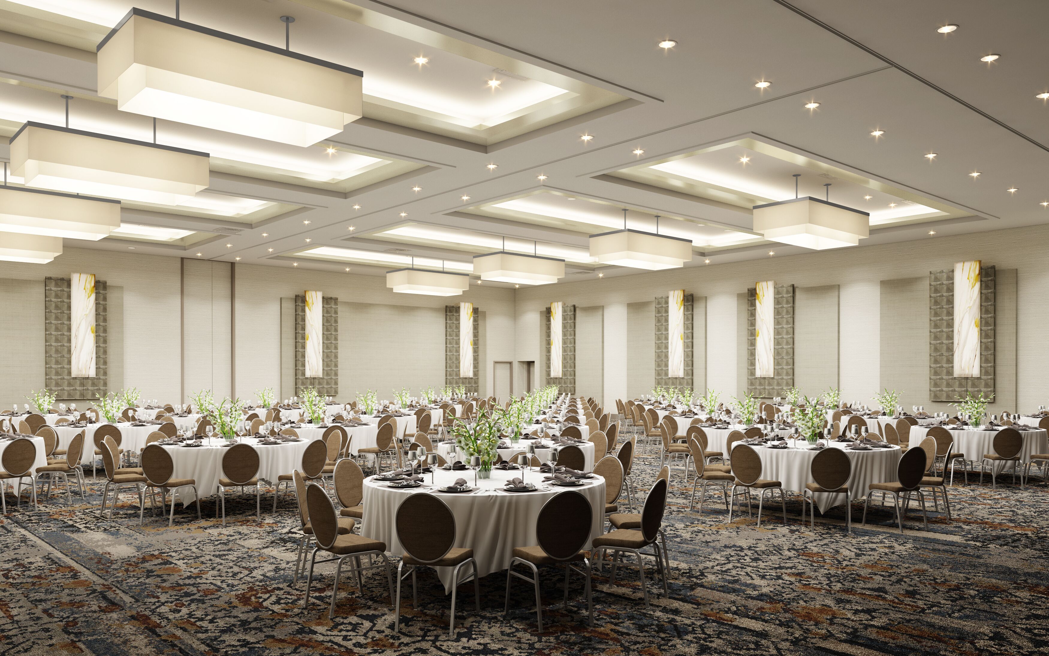 A large banquet hall with round tables, chairs, and a patterned carpet.