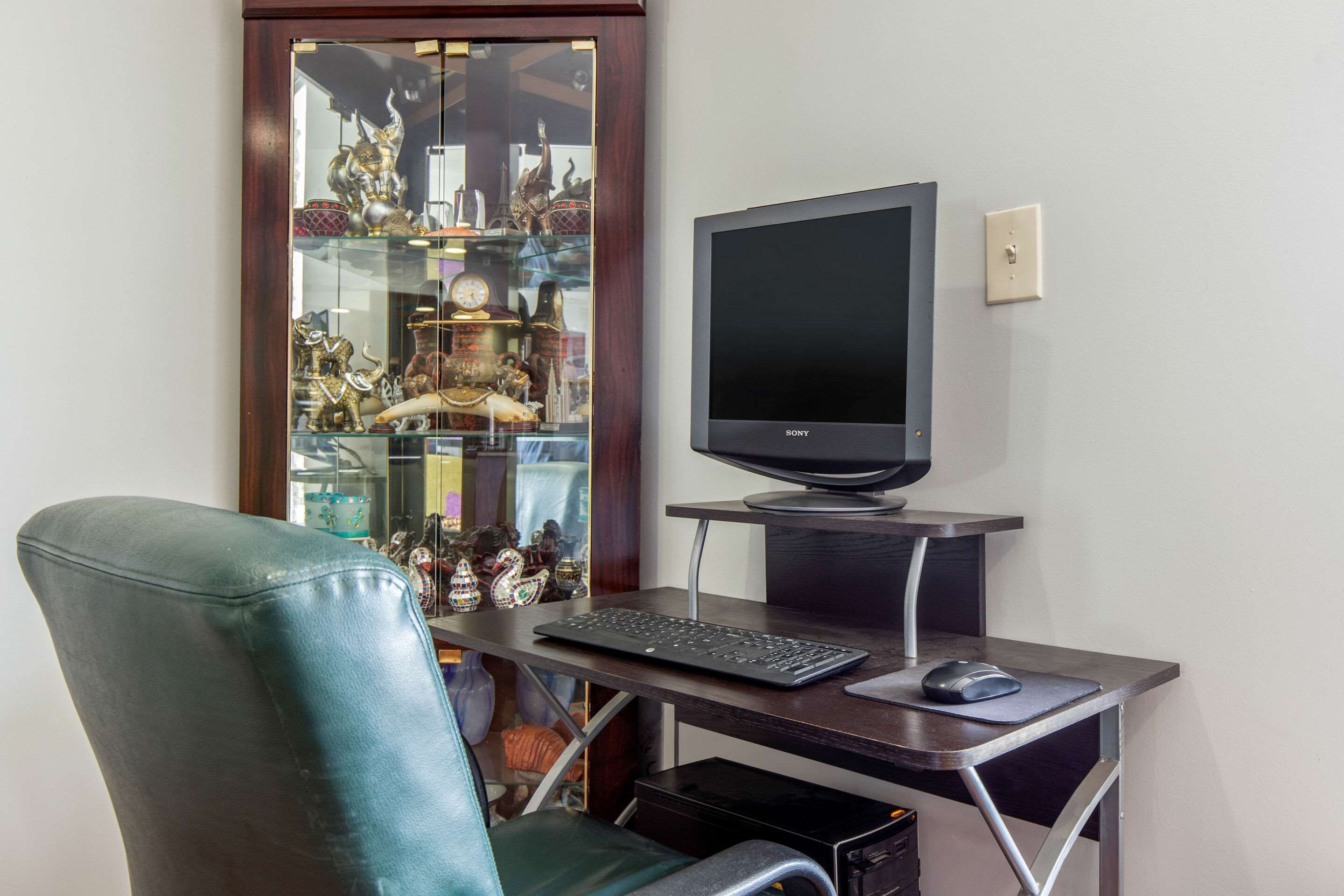 A home office setup with a desk, computer, keyboard, mouse, and a chair.