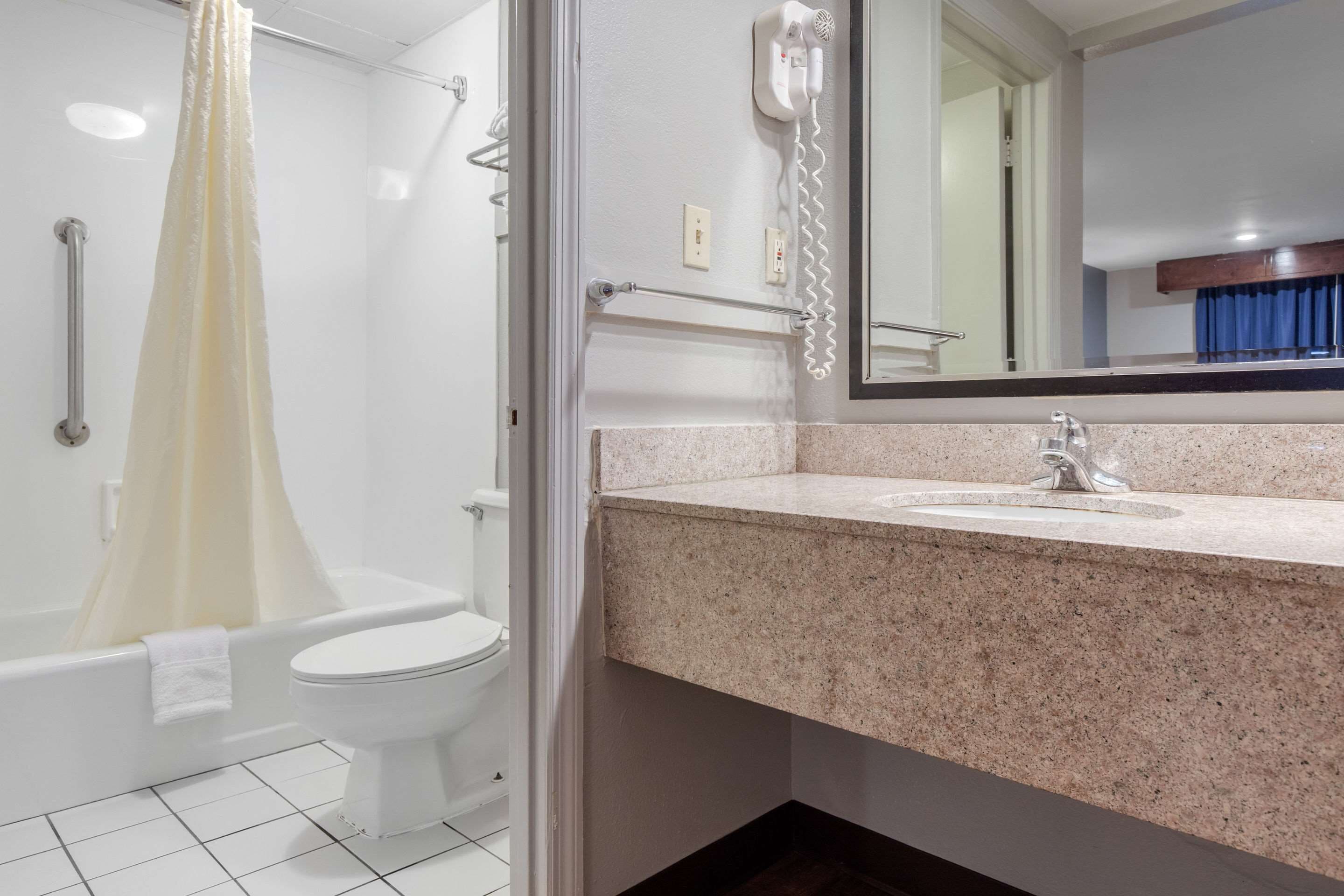 A bathroom with a shower, toilet, and sink.