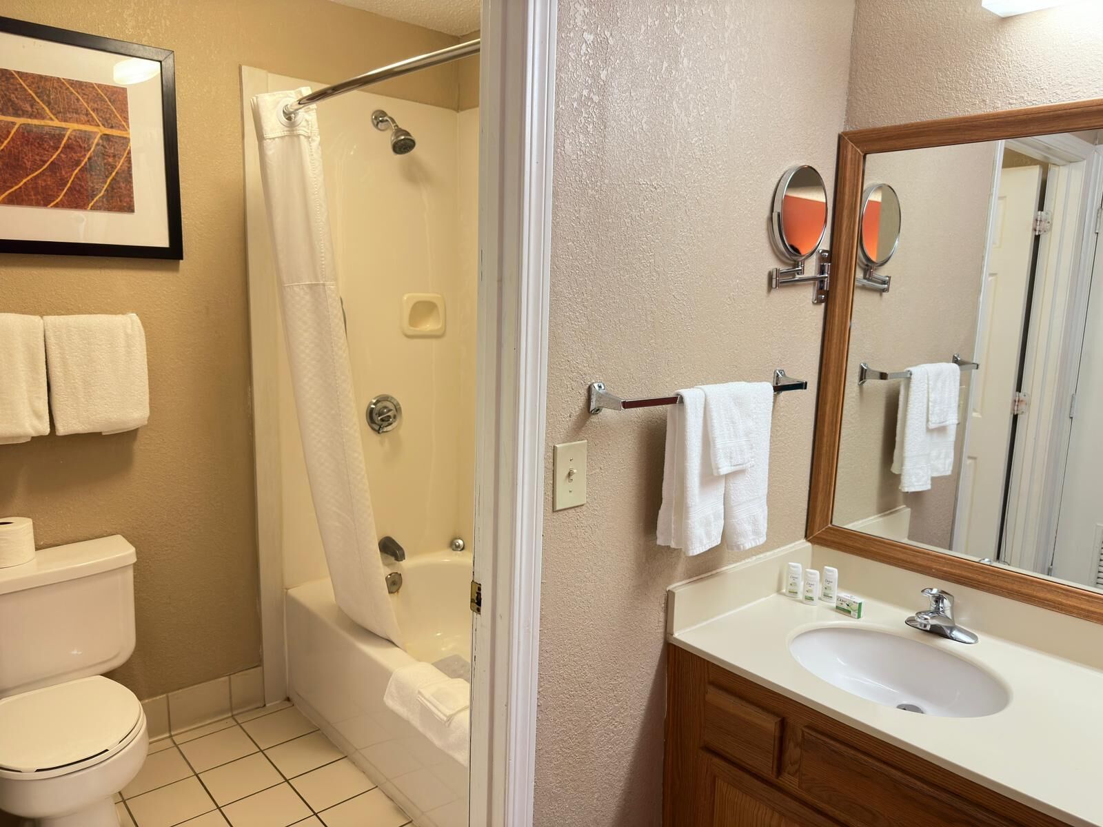 A bathroom with a bathtub, toilet, sink, and a mirror.