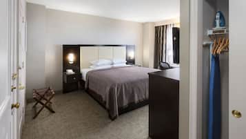 Una habitación de hotel con cama, mesitas de noche, escritorio y una silla.