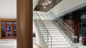 A modern interior with a glass staircase, a wooden column, and a store named "The Oceanaire". - The Westin Galleria Dallas (Dallas)