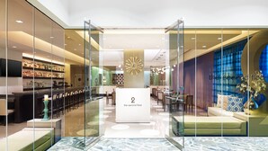 A hotel lobby with a reception desk, seating area, and a bar. - The Westin Galleria Dallas (Dallas)