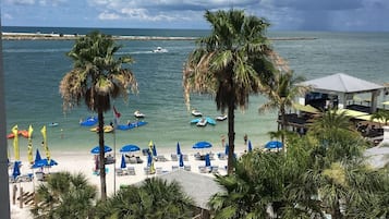 Enjoy breathtaking views of the ocean from your balcony overlooking the sandy beach and palm trees.