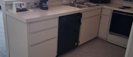 Cocina moderna equipada con lavavajillas, microondas, estufa y pileta.