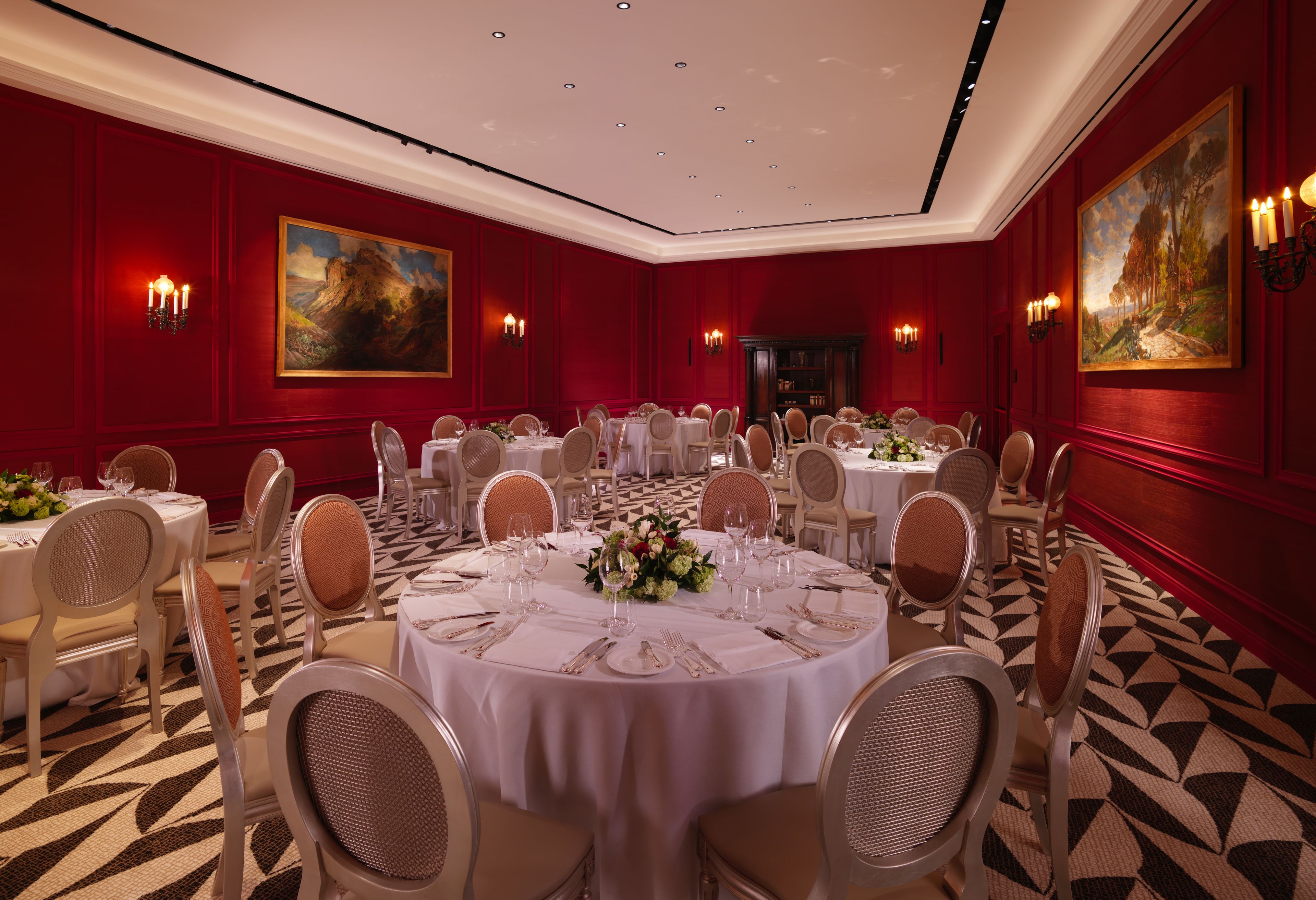Un comedor elegante con mesas redondas, manteles blancos y sillas color beige.