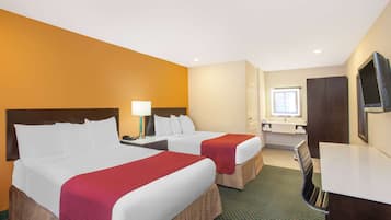 A hotel room with two beds, a desk, a chair, a TV, and a bathroom.