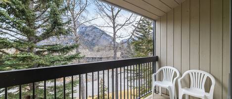 A balcony with a view of trees and mountains.