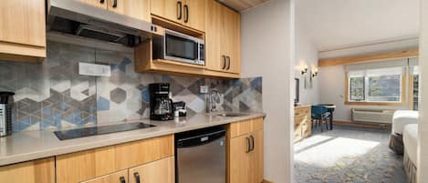 Una cocina moderna con armarios de madera, lavavajillas de acero inoxidable y microondas.