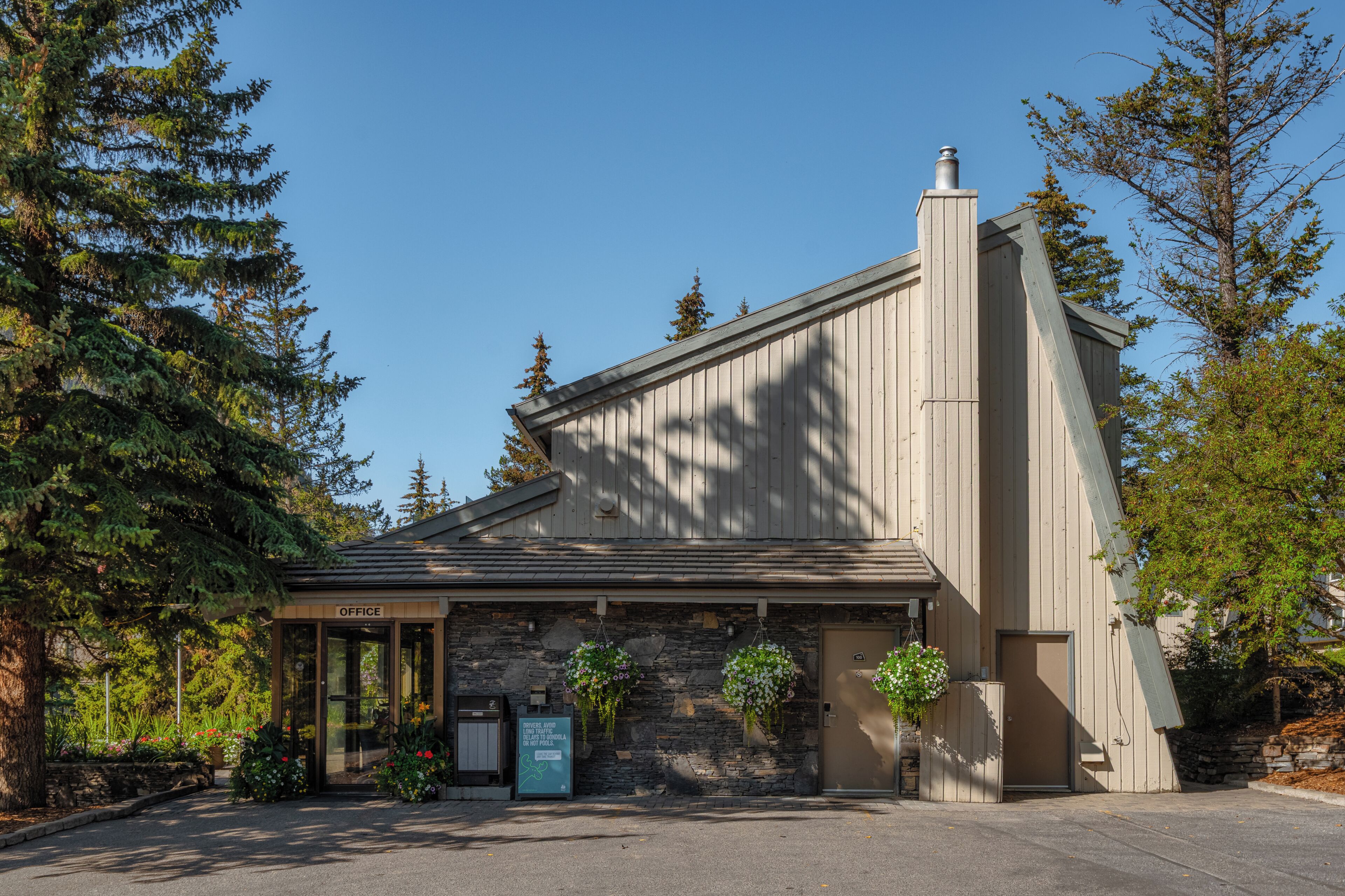 A building with a stone facade, a wooden entrance, and a sign that reads 'OFFICE'.