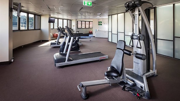 A gym with treadmills, a weight machine, and exercise balls.