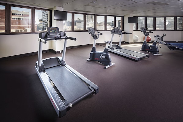 A gym with treadmills, ellipticals, and a rowing machine.