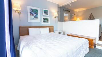 A hotel room with a large bed, bedside tables, wall-mounted lamps, and artwork.
