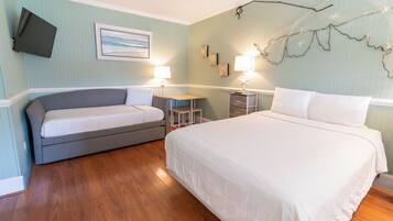 A bedroom with a bed, a sofa, a desk, and a TV.