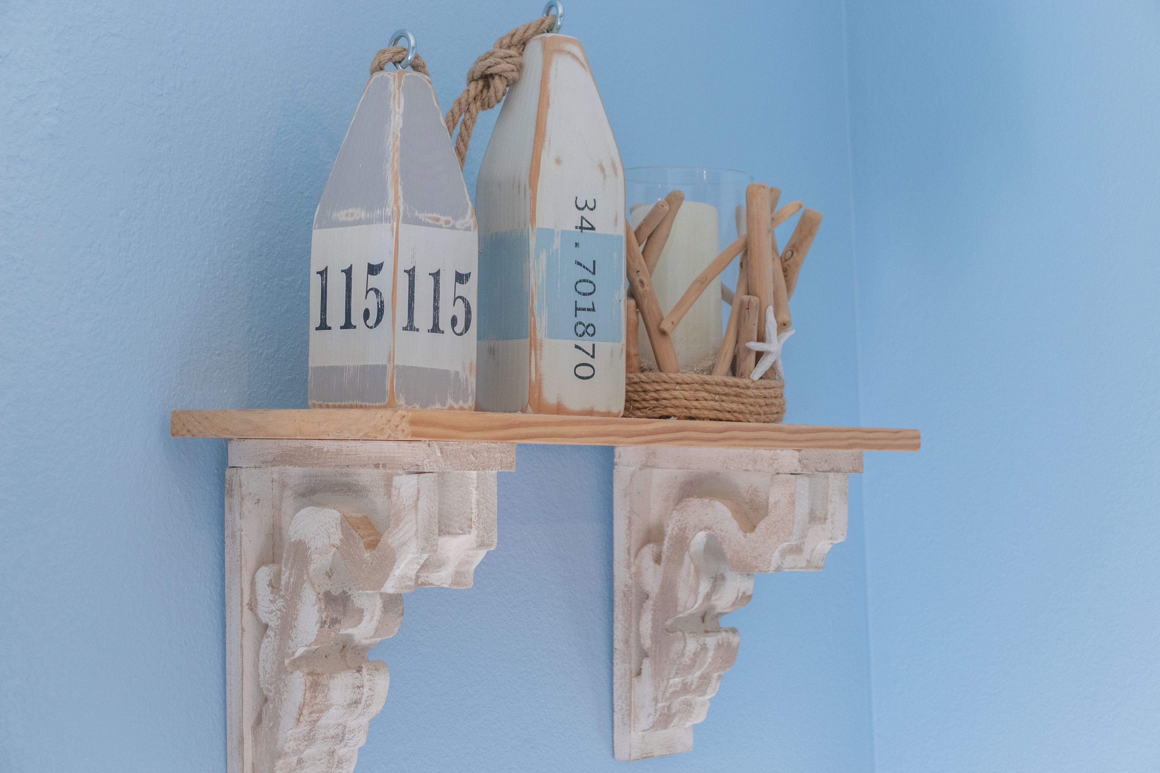 A rustic wooden shelf with two decorative bottles and a basket of breadsticks.