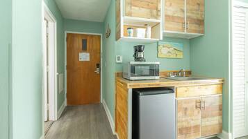 A compact kitchen with a dishwasher, microwave, and wooden cabinets.