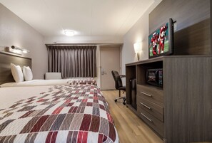 A hotel room with a large bed, a desk with a chair, a television, and a microwave. - Red Roof Inn Detroit - Farmington Hills (Farmington Hills)
