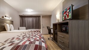 A hotel room with a large bed, a desk with a chair, a television, and a microwave. - Red Roof Inn Detroit - Farmington Hills (Farmington Hills)