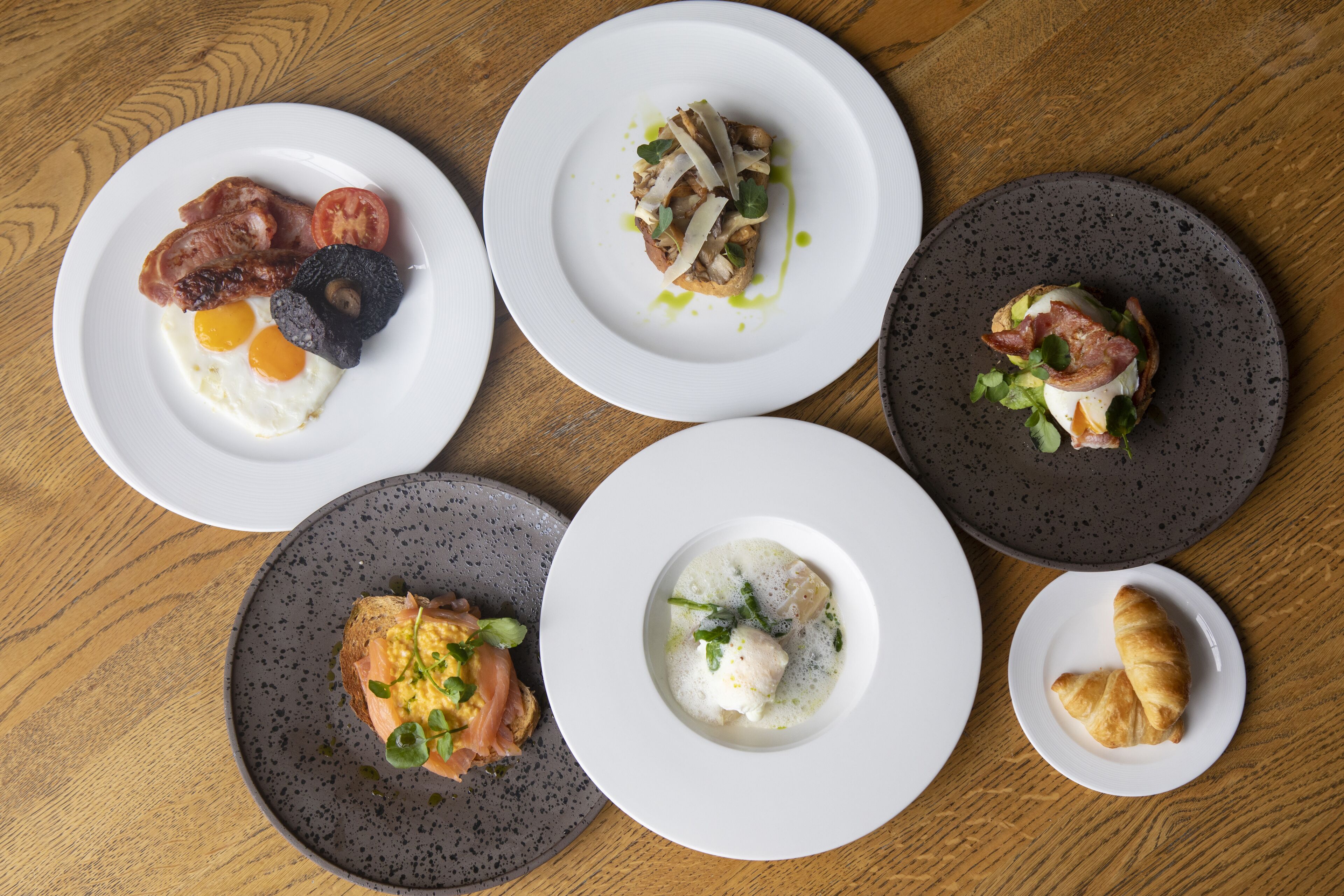 Une table avec cinq assiettes de nourriture, chacune contenant un plat différent.