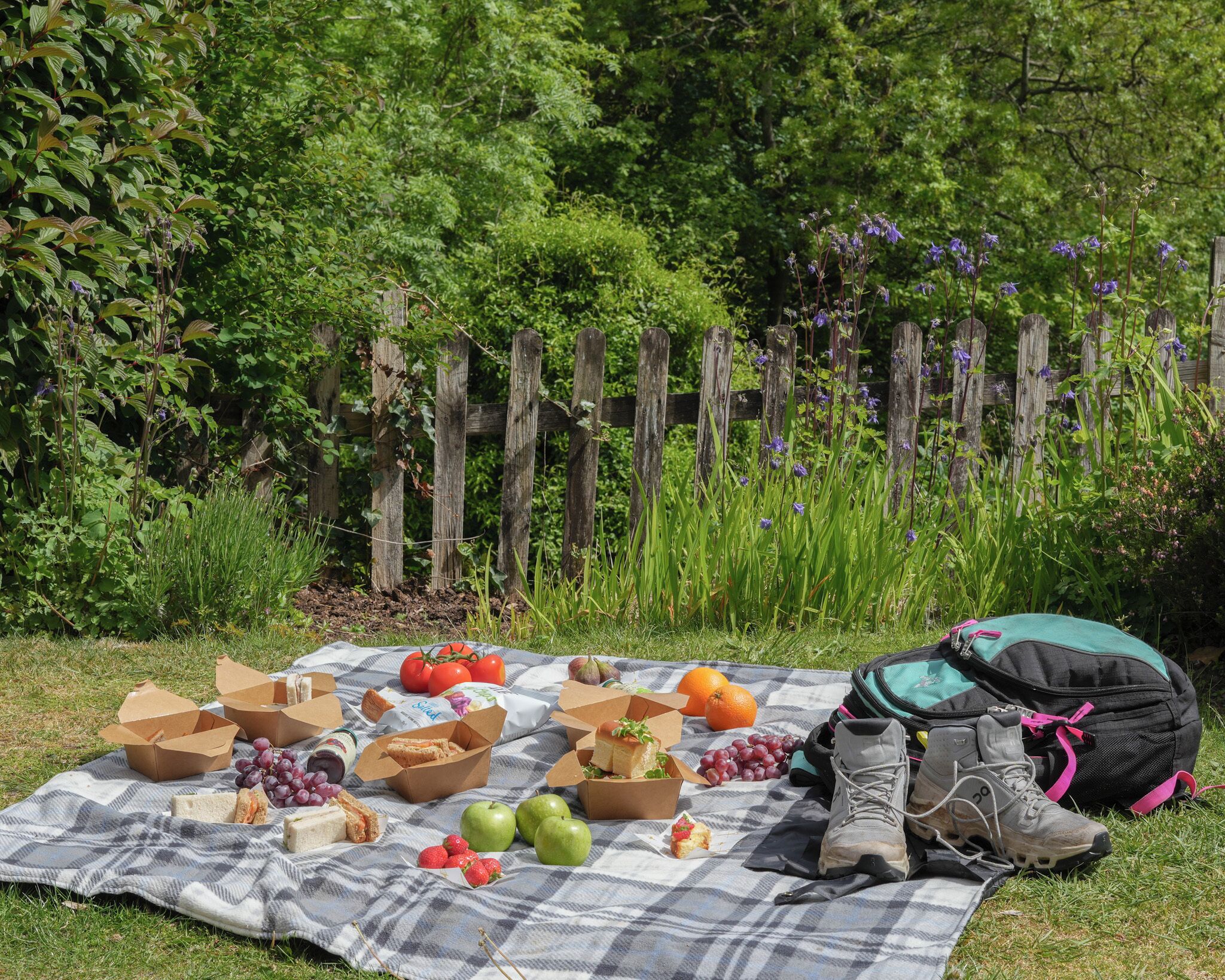 Un montaje para picnic con comida y una mochila sobre una manta.