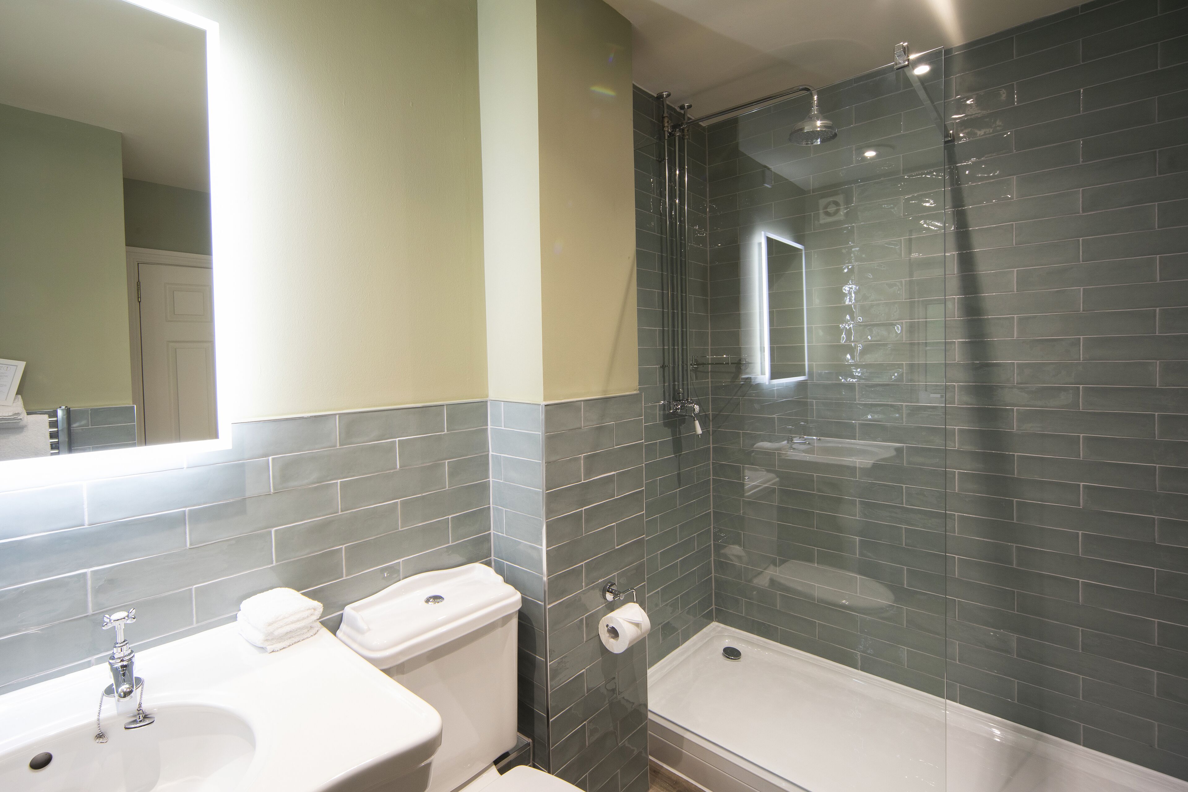 A bathroom with a sink, toilet, and shower.