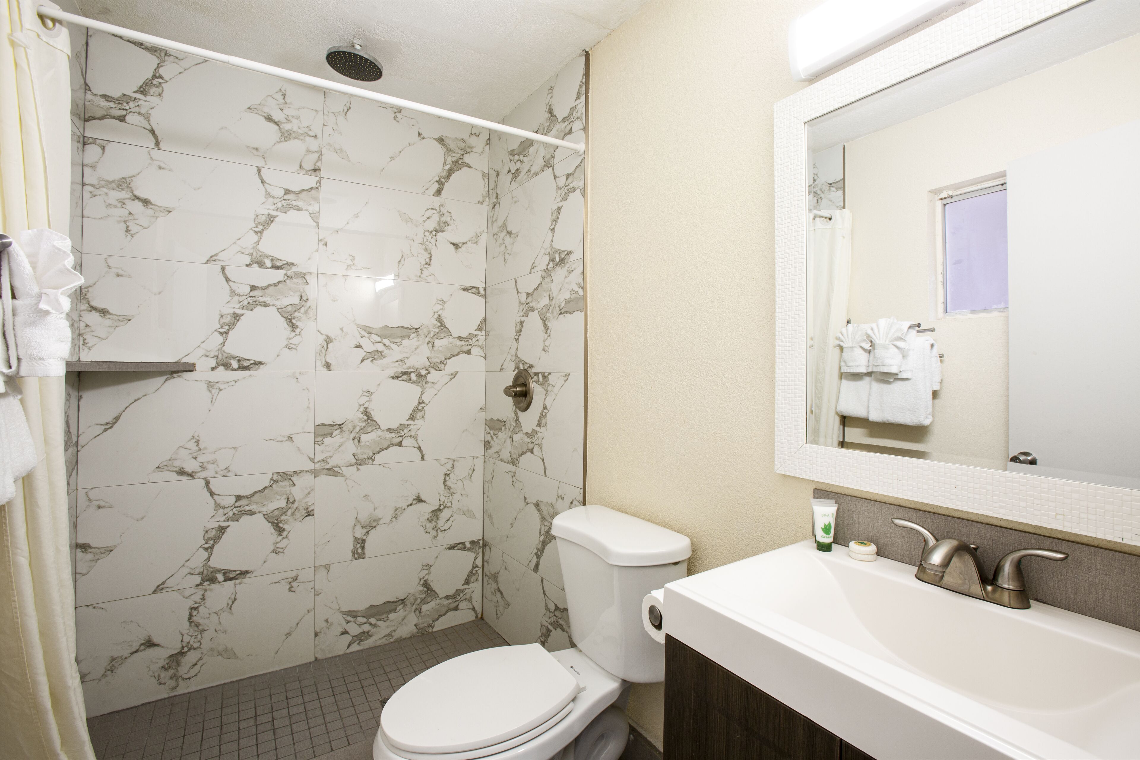 A bathroom with a toilet, sink, and shower area.