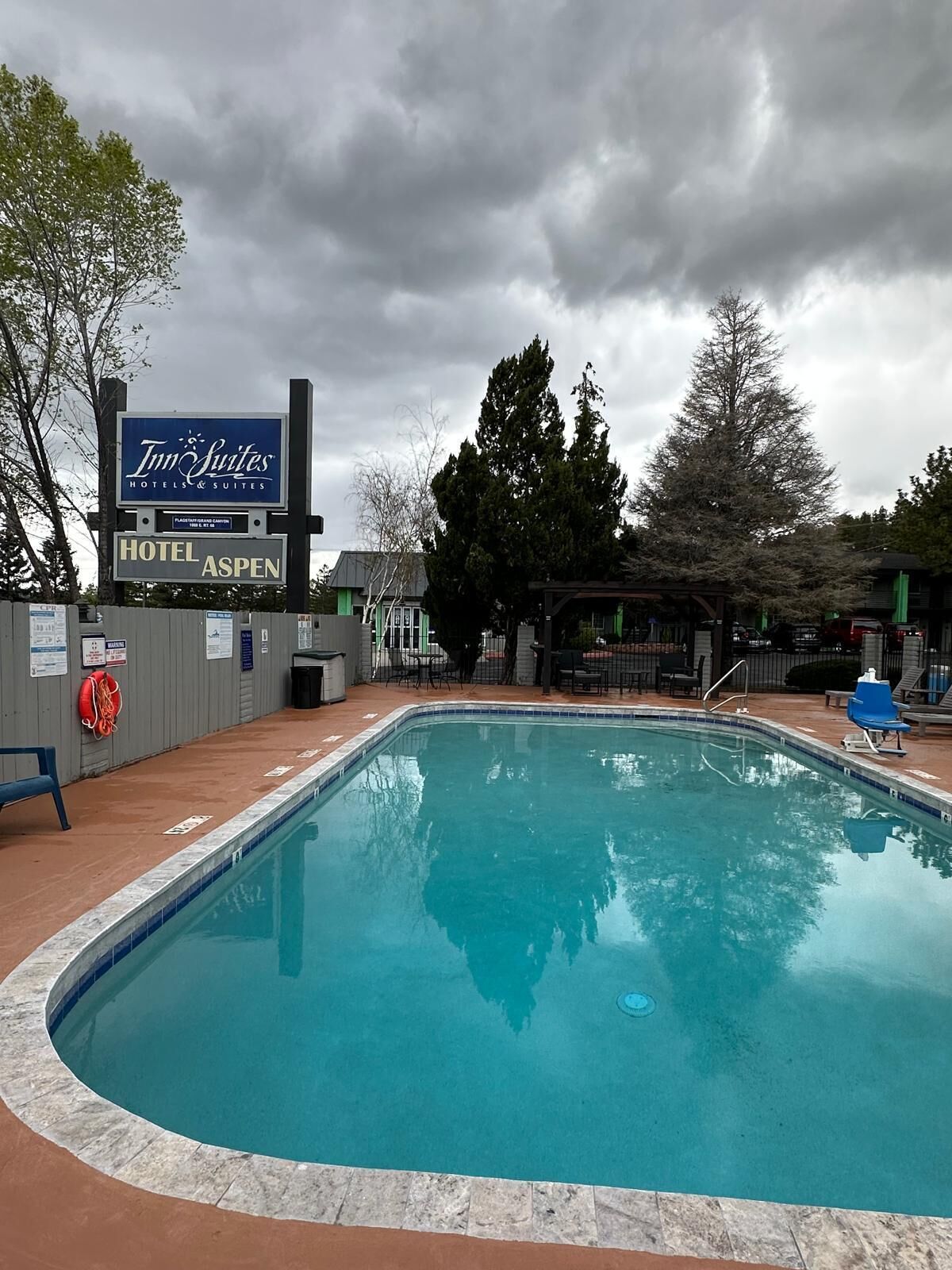 A swimming pool with a sign for 'Inn Suites Hotels & Suites Aspen' in the background.