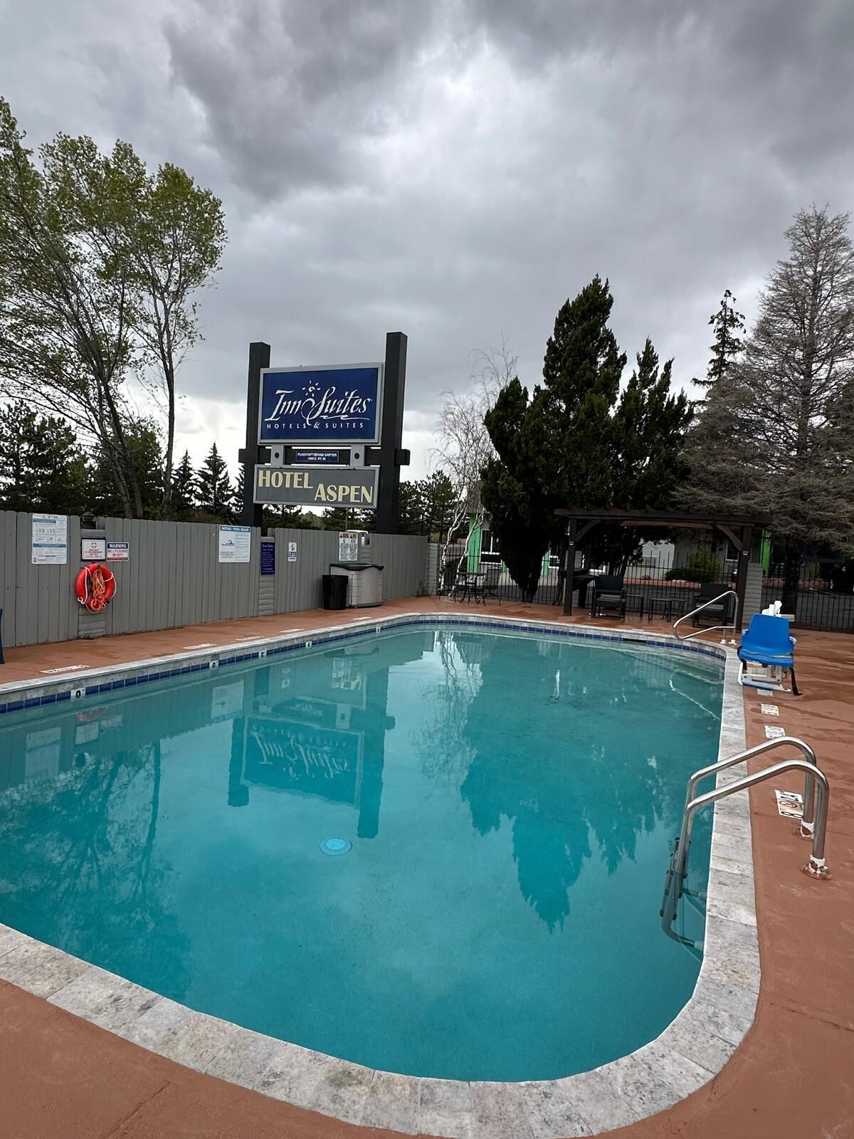 Una piscina con un cartello che indica 'Hotel Aspen' e una torretta per i bagnini.
